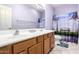 Bright bathroom featuring a double vanity, oak cabinetry, and light purple walls at 81 E Rock Wren Dr, San Tan Valley, AZ 85143