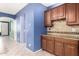 A kitchen with blue accent walls, a tiled backsplash, wood cabinets, and light colored tiled floors at 81 E Rock Wren Dr, San Tan Valley, AZ 85143