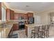 This kitchen features a granite island with seating, stainless steel appliances, and dark wood cabinets at 81 E Rock Wren Dr, San Tan Valley, AZ 85143
