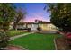 Beautiful backyard with green grass, brick-lined flowerbeds and patio, perfect for entertaining at 8228 E Oak St, Scottsdale, AZ 85257