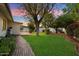 Lush backyard with brick pathway, green lawn and mature shade trees at 8228 E Oak St, Scottsdale, AZ 85257