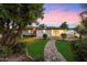 Backyard with manicured lawn and inviting brick pathway to a covered patio at 8228 E Oak St, Scottsdale, AZ 85257