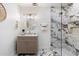 A bathroom featuring marble tile, a glass enclosed shower, updated lighting, and a circular mirror at 8228 E Oak St, Scottsdale, AZ 85257