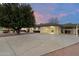 Inviting single-story home with a covered parking area, mature landscaping, and a large driveway at 8228 E Oak St, Scottsdale, AZ 85257