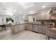 An open kitchen with grey cabinets, granite countertops, stainless steel appliances, and view of the living room at 8228 E Oak St, Scottsdale, AZ 85257