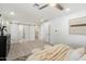 A bedroom with light hardwood floors, a ceiling fan, and sliding barn doors leading to the bathroom at 8228 E Oak St, Scottsdale, AZ 85257