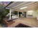 Covered patio with a brick floor, hanging swing, and a serving bar at 8228 E Oak St, Scottsdale, AZ 85257