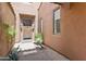 Inviting entryway featuring a solid wood door, stylish sconces, and desert landscaping at 8512 E Gilded Perch Dr, Scottsdale, AZ 85255