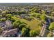 Aerial shot of the community park featuring green space, a tennis court, and mature trees at 880 E Wimpole Ave, Gilbert, AZ 85297