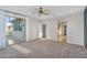 Spacious bedroom with plush carpet, ceiling fan, and sliding glass doors to a balcony at 880 E Wimpole Ave, Gilbert, AZ 85297