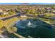 Aerial view of a serene community lake with fountain, surrounded by lush landscaping and homes at 880 E Wimpole Ave, Gilbert, AZ 85297