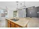 A kitchen island featuring granite countertop, stylish lighting, stainless steel sink, and modern fixtures at 880 E Wimpole Ave, Gilbert, AZ 85297