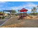 Community playground with slides, stairs, and benches under a pergola with mature landscaping at 880 E Wimpole Ave, Gilbert, AZ 85297