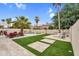 Expansive backyard with a pristine pool, lush artificial grass, and a cozy fire pit area at 9225 E Pine Valley Rd, Scottsdale, AZ 85260