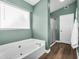 Bright bathroom features a large bathtub, a separate shower with glass doors, and wood-look flooring at 9225 E Pine Valley Rd, Scottsdale, AZ 85260