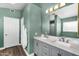 Bathroom featuring a double sink vanity, a large mirror with decorative lighting, and a separate door to the toilet at 9225 E Pine Valley Rd, Scottsdale, AZ 85260
