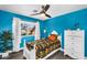Bright blue bedroom with light-colored hardwood floor, decorated bed, chest of drawers, and a bright window at 9225 E Pine Valley Rd, Scottsdale, AZ 85260