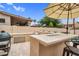 Outdoor kitchen has a built-in sink, grill, and storage space for outdoor meal preparation and dining enjoyment at 9225 E Pine Valley Rd, Scottsdale, AZ 85260