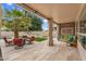 The covered outdoor patio with comfortable seating and a view of the pool and landscaped backyard at 9225 E Pine Valley Rd, Scottsdale, AZ 85260