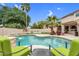 Inviting backyard with a sparkling pool, water feature, comfortable seating area, and lush tropical landscaping at 9225 E Pine Valley Rd, Scottsdale, AZ 85260
