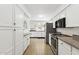 Well-lit kitchen featuring white cabinets, granite countertops, stainless steel appliances, and tile flooring at 11627 S Jokake St, Phoenix, AZ 85044