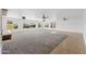 Bright and spacious living room featuring plush carpet, tile accents, recessed lights, and multiple windows at 11627 S Jokake St, Phoenix, AZ 85044