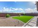 Private backyard featuring artificial grass, gravel, desert landscaping, and a paved walkway at 19875 W Badgett Ln, Litchfield Park, AZ 85340
