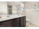 Modern bathroom featuring double sinks, a walk-in shower, and bright natural light at 19875 W Badgett Ln, Litchfield Park, AZ 85340
