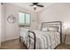 Bright bedroom featuring a stylish bed, large window with a view, and a glass side table at 19875 W Badgett Ln, Litchfield Park, AZ 85340