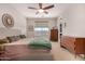 Neutral-toned bedroom featuring a plush bed, wooden furniture, and bright natural light at 19875 W Badgett Ln, Litchfield Park, AZ 85340