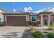 Charming home exterior featuring a well-maintained yard, two-car garage, and covered entryway at 19875 W Badgett Ln, Litchfield Park, AZ 85340