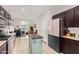 Bright, open kitchen featuring a center island, stainless steel appliances, and dark cabinetry at 19875 W Badgett Ln, Litchfield Park, AZ 85340