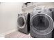 Laundry room features modern, side-by-side washer and dryer units with built-in storage shelves for organization at 19875 W Badgett Ln, Litchfield Park, AZ 85340