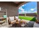 Covered patio boasts modern outdoor seating and lush turf, perfect for entertaining and relaxing outside at 19875 W Badgett Ln, Litchfield Park, AZ 85340