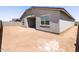 View of the unlandscaped backyard with covered patio, showing the home's exterior at 37111 W Parador Ln, Maricopa, AZ 85138