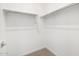 Spacious walk-in closet featuring ample shelving and a neutral carpet at 37111 W Parador Ln, Maricopa, AZ 85138