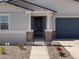 Close-up of a gated entrance with stone accents and a well-maintained walkway at 37111 W Parador Ln, Maricopa, AZ 85138