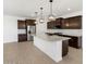 Modern kitchen features granite countertops, dark cabinets, stainless steel appliances, and pendant lighting at 37111 W Parador Ln, Maricopa, AZ 85138