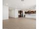 Bright, open-concept living space with tile floors flowing into a modern kitchen with dark cabinets and marble countertops at 37111 W Parador Ln, Maricopa, AZ 85138