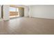 Bright, open-concept living space featuring tile floors, backyard patio access, and a hallway at 37111 W Parador Ln, Maricopa, AZ 85138
