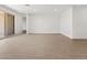 Bright, open-concept living space featuring tile floors, access to the backyard patio, and a hallway at 37111 W Parador Ln, Maricopa, AZ 85138