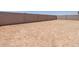 Large dirt backyard with high concrete block wall at 37151 W Parador Ln, Maricopa, AZ 85138