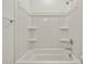 A clean bathtub and shower combination with built-in shelving at 37151 W Parador Ln, Maricopa, AZ 85138