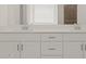 Close-up of a modern bathroom vanity featuring a double sink and bright white drawers at 37151 W Parador Ln, Maricopa, AZ 85138