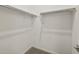 Well-organized walk-in closet featuring ample shelving and carpeted flooring at 37151 W Parador Ln, Maricopa, AZ 85138