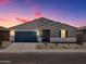 Beautiful single-story home featuring a blue garage door and complementary stone landscaping at 37151 W Parador Ln, Maricopa, AZ 85138