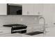 Up close shot of modern kitchen appliances, stylish backsplash, granite countertop and stainless sink at 37151 W Parador Ln, Maricopa, AZ 85138
