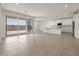 Open living area flows into a modern kitchen with stainless steel appliances and white cabinetry at 37151 W Parador Ln, Maricopa, AZ 85138