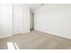 A simplistic room features neutral carpeting, white walls, and a door leading to another room at 4032 S 176Th Dr, Goodyear, AZ 85338