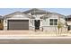 Charming single-story home featuring a grey exterior, brick accents, and a well-maintained front yard at 4032 S 176Th Dr, Goodyear, AZ 85338